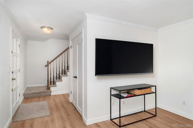 foyer entrance with crown molding and light hardwood / wood-style floors