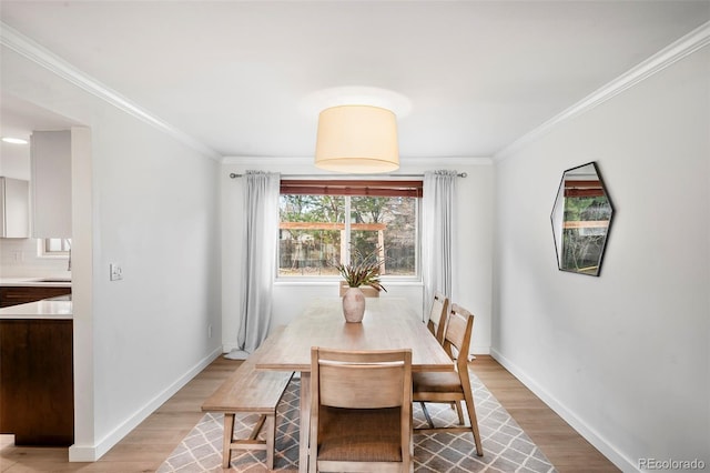 dining area with light hardwood / wood-style floors and crown molding