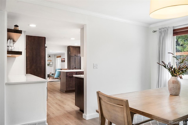 dining room featuring light hardwood / wood-style flooring and crown molding