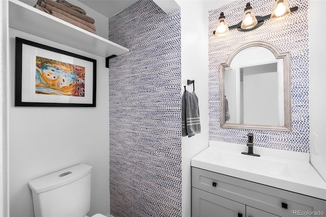 bathroom featuring decorative backsplash, vanity, and toilet