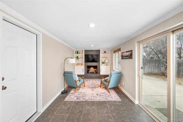 unfurnished room with built in shelves, a large fireplace, dark tile patterned floors, and crown molding