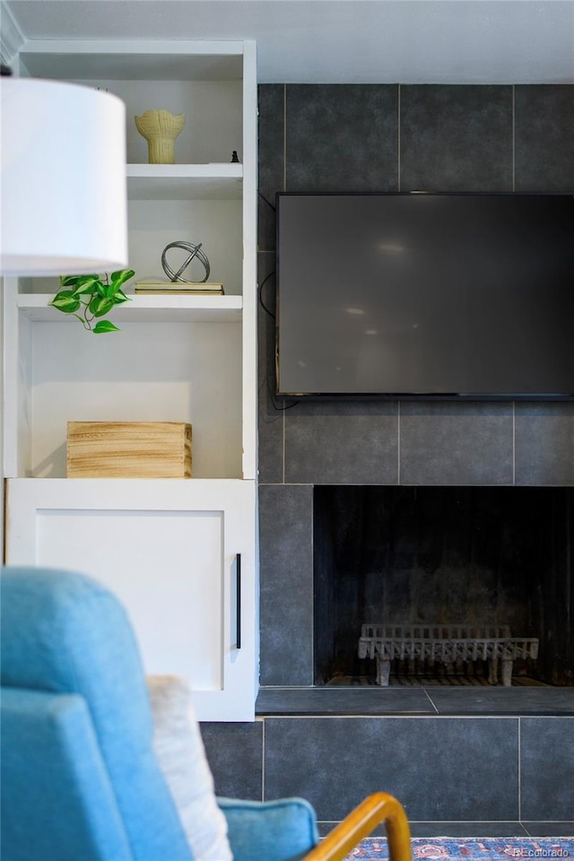 room details featuring a tile fireplace and built in features