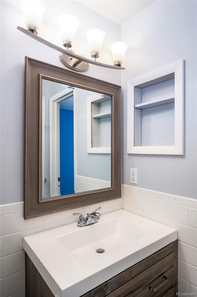 bathroom with vanity and tile walls