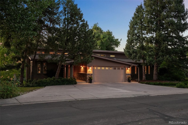 3 Twilight Dr, Wheat Ridge, CO 80215 - view of front of house with stone siding, an attached garage, and concrete driveway