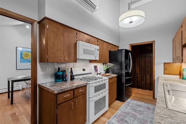 3 Twilight Dr, Wheat Ridge, CO 80215 - kitchen with white appliances, light wood finished floors, tasteful backsplash, a baseboard radiator, and a wall mounted air conditioner