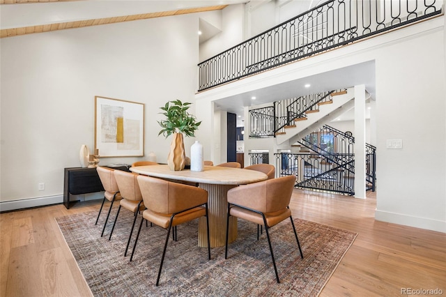 2289 Hiwan Dr, Evergreen, CO 80439 - dining space featuring high vaulted ceiling, wood finished floors, and stairway