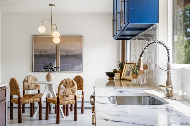 2289 Hiwan Dr, Evergreen, CO 80439 - kitchen with light stone countertops, blue cabinets, and pendant lighting