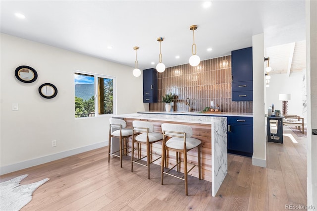 2289 Hiwan Dr, Evergreen, CO 80439 - kitchen with blue cabinets, a breakfast bar area, light countertops, light wood finished floors, and recessed lighting