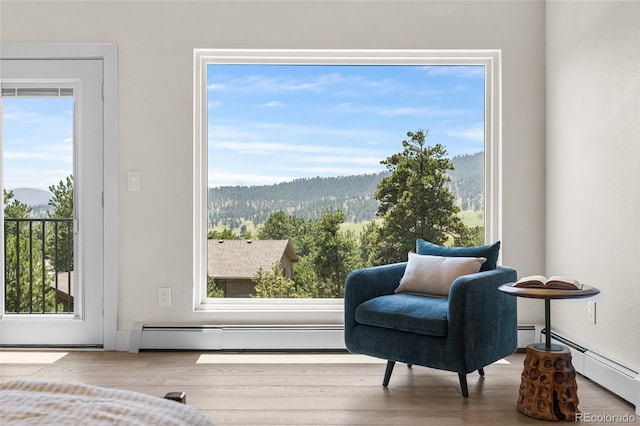 2289 Hiwan Dr, Evergreen, CO 80439 - sitting room featuring a baseboard heating unit, a mountain view, and wood finished floors