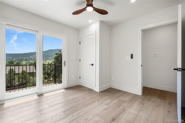 2289 Hiwan Dr, Evergreen, CO 80439 - unfurnished bedroom featuring access to outside, recessed lighting, light wood-style floors, a mountain view, and ceiling fan