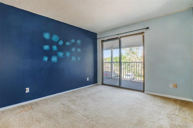 carpeted empty room with baseboards and a textured ceiling