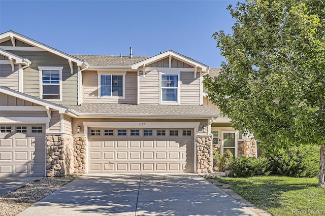 6187 Wescroft Ave, Castle Rock, CO 80104 - view of front facade with stone siding, driveway, an attached garage, board and batten siding, and a shingled roof