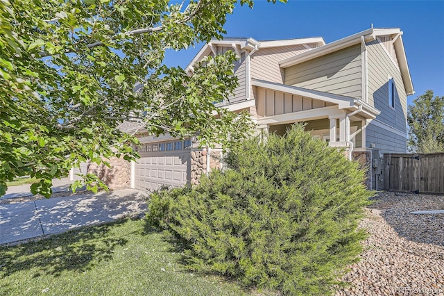 6187 Wescroft Ave, Castle Rock, CO 80104 - view of side of home with fence, driveway, an attached garage, and stone siding