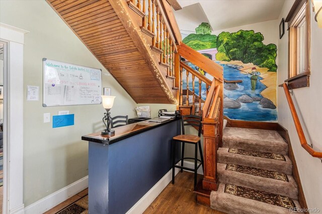 stairway with wood ceiling, lofted ceiling, and hardwood / wood-style flooring