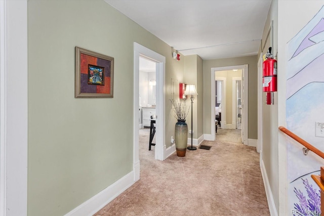 hallway featuring light colored carpet