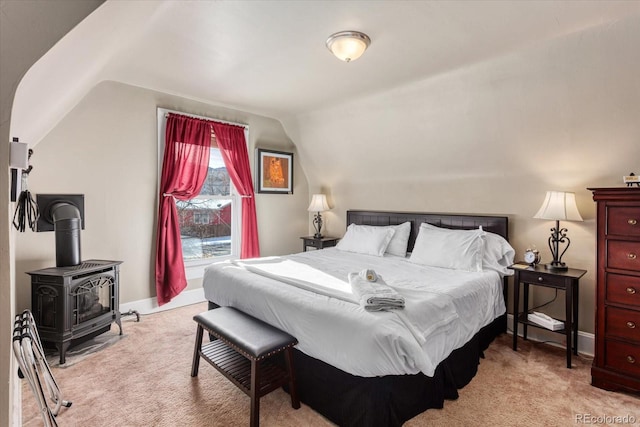 bedroom featuring light carpet, vaulted ceiling, and a wood stove