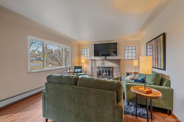 living room with a fireplace, a baseboard radiator, and hardwood / wood-style flooring