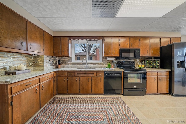 kitchen featuring black appliances, backsplash, and sink