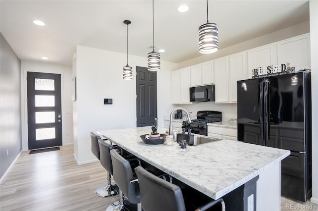 26985 E Bayaud Ave, Aurora, CO 80018 - kitchen featuring black appliances, a sink, an island with sink, recessed lighting, and white cabinetry