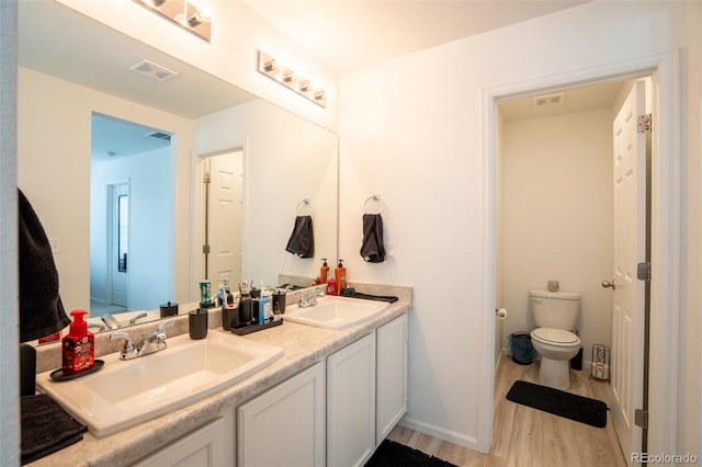 26985 E Bayaud Ave, Aurora, CO 80018 - bathroom with wood finished floors, double vanity, and toilet