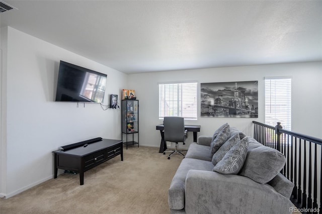 26985 E Bayaud Ave, Aurora, CO 80018 - living area featuring healthy amount of natural light, light colored carpet, an office area, and baseboards