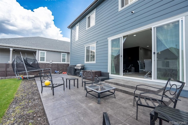 26985 E Bayaud Ave, Aurora, CO 80018 - view of patio / terrace featuring a trampoline, area for grilling, and an outdoor living space with a fire pit