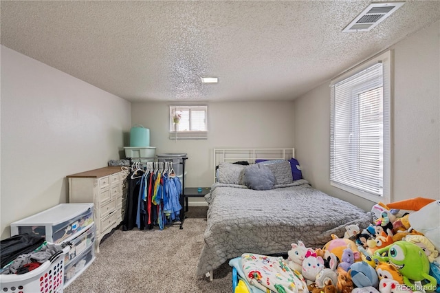 bedroom with light colored carpet and a textured ceiling