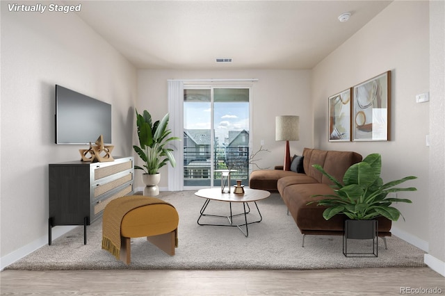 living room featuring baseboards, visible vents, and wood finished floors