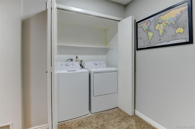 washroom featuring washing machine and clothes dryer, laundry area, light carpet, baseboards, and visible vents