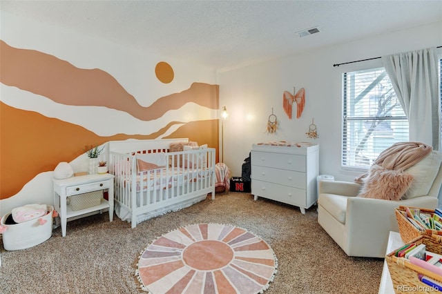 bedroom with visible vents, carpet, and a nursery area
