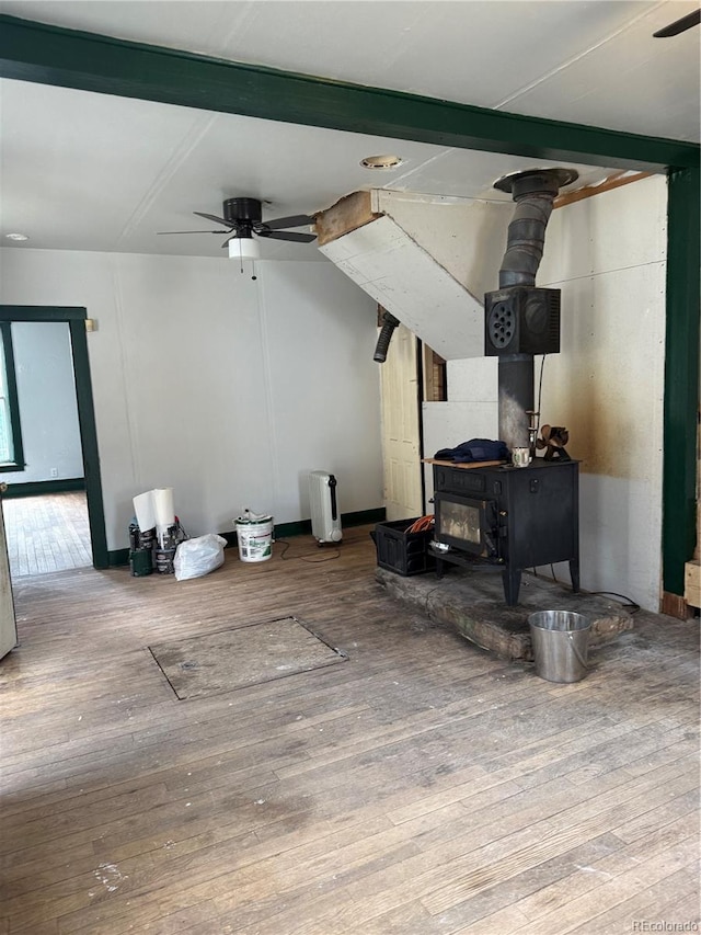 219 Colorado Blvd, Idaho Springs, CO 80452 - living room with a wood stove, hardwood / wood-style flooring, ceiling fan, baseboards, and beam ceiling