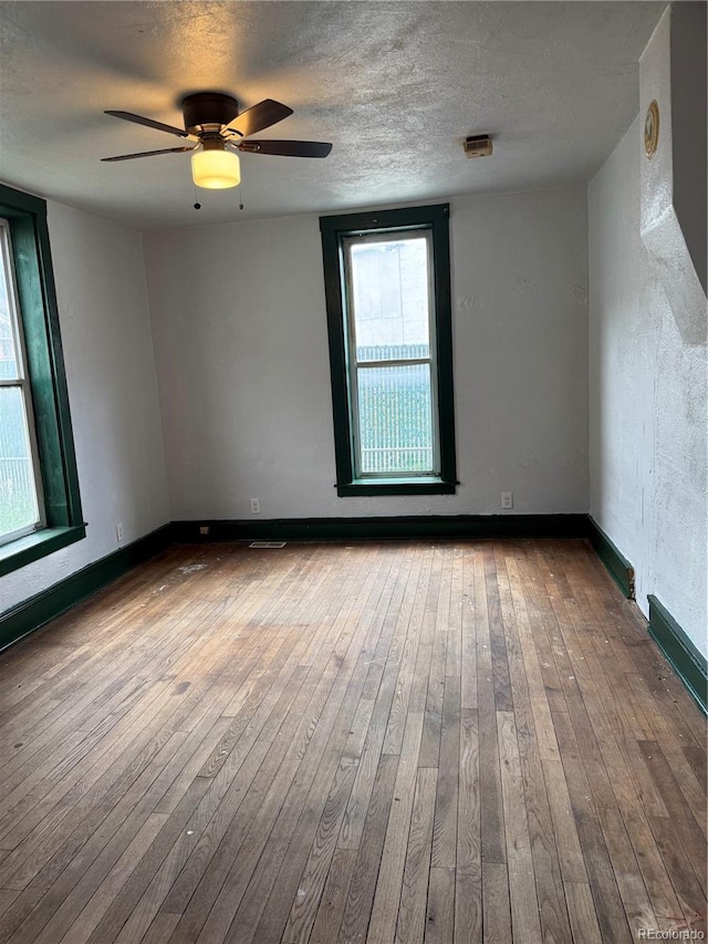 219 Colorado Blvd, Idaho Springs, CO 80452 - empty room with hardwood / wood-style floors, a textured ceiling, a ceiling fan, and baseboards