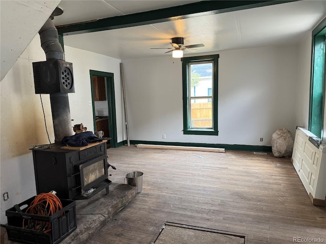 219 Colorado Blvd, Idaho Springs, CO 80452 - living room featuring a wood stove, wood finished floors, ceiling fan, and baseboards