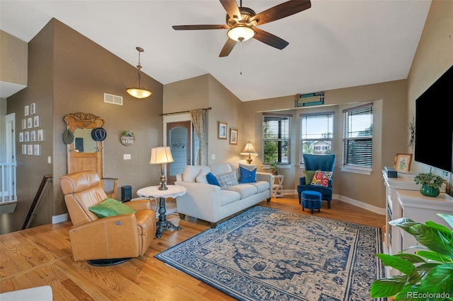 living area featuring visible vents, baseboards, light wood-style floors, and a ceiling fan