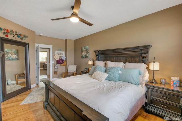 bedroom featuring baseboards, a ceiling fan, and light wood finished floors