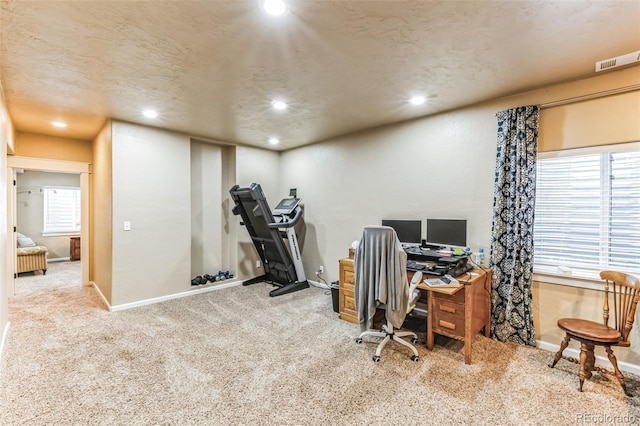 carpeted office featuring a textured ceiling, recessed lighting, visible vents, and baseboards