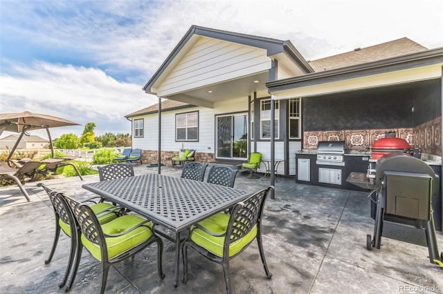 view of patio with outdoor dining space, an outdoor kitchen, and grilling area