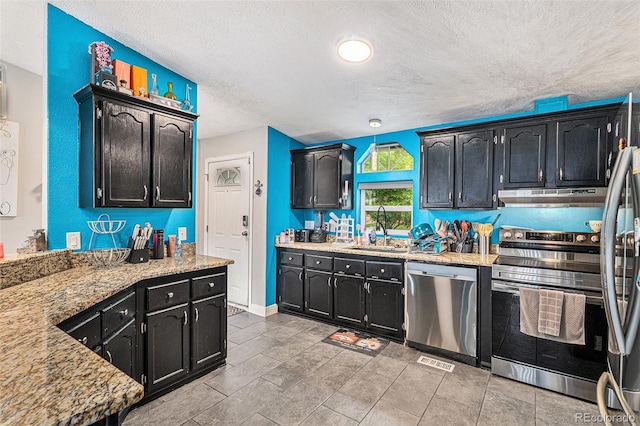 1390 W 78th Cir, Denver, CO 80221 - kitchen with appliances with stainless steel finishes, ventilation hood, a textured ceiling, dark cabinets, and light countertops