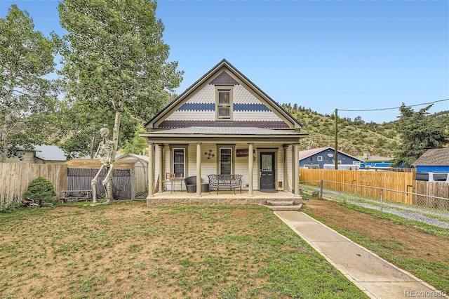 view of front facade with covered porch, a storage shed, and a front yard