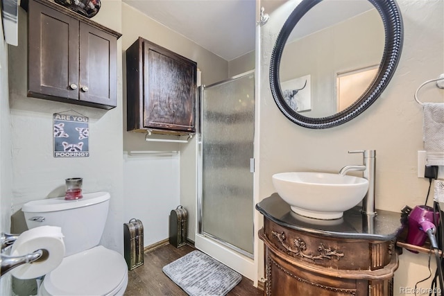 bathroom featuring vanity, hardwood / wood-style flooring, an enclosed shower, and toilet