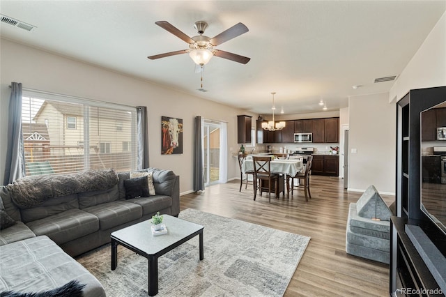 7232 Shavano Ave, Frederick, CO 80504 - living area featuring a chandelier, light wood finished floors, a ceiling fan, and baseboards