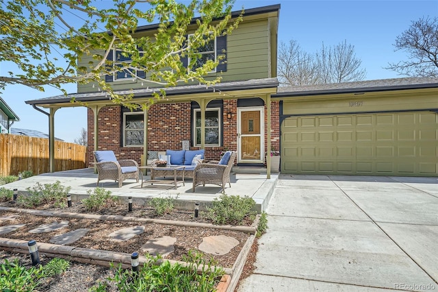 view of front of house with brick siding, fence, an outdoor living space, a garage, and concrete driveway