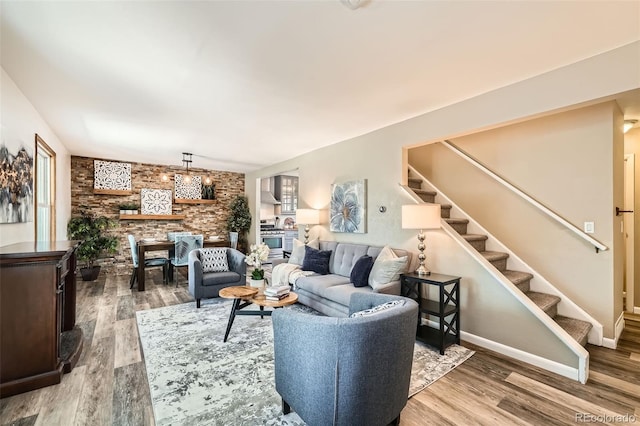 living room featuring stairs, wood finished floors, and baseboards