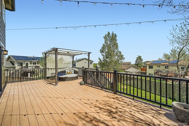 wooden deck featuring a pergola, a residential view, and fence