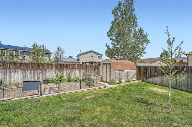 view of yard with a shed, an outbuilding, and a vegetable garden