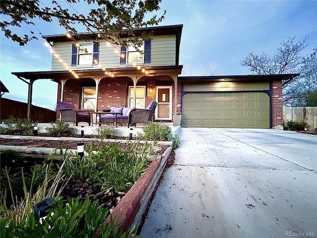 traditional-style home with brick siding, driveway, covered porch, and an attached garage