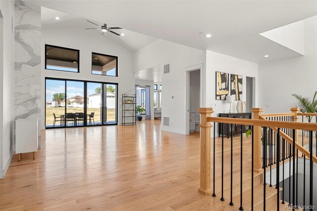 hall featuring high vaulted ceiling and light hardwood / wood-style floors