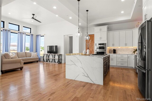 kitchen featuring decorative backsplash, white cabinetry, ceiling fan, and light hardwood / wood-style floors