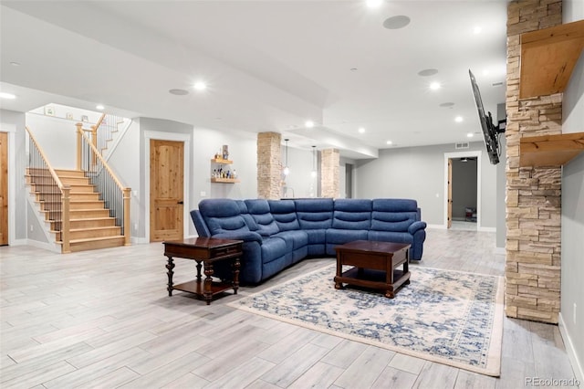 living room featuring decorative columns and light hardwood / wood-style floors