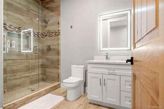 bathroom featuring vanity, walk in shower, and toilet